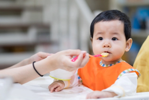 Ibu menyuapi bayi dengan sendok Ibu menyuapi bayi dengan sendok