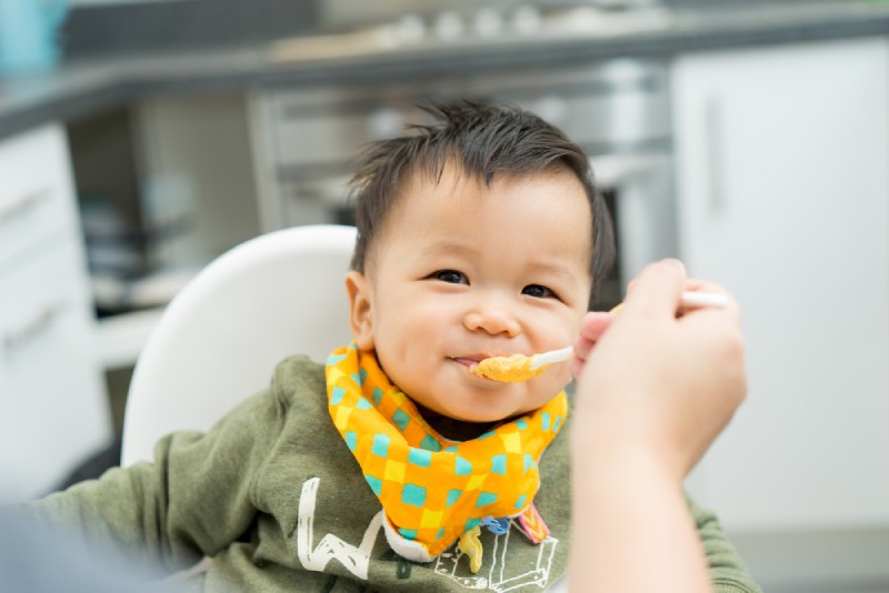 Ibu menyuapi bayi dengan sendok Ibu menyuapi bayi dengan sendok
